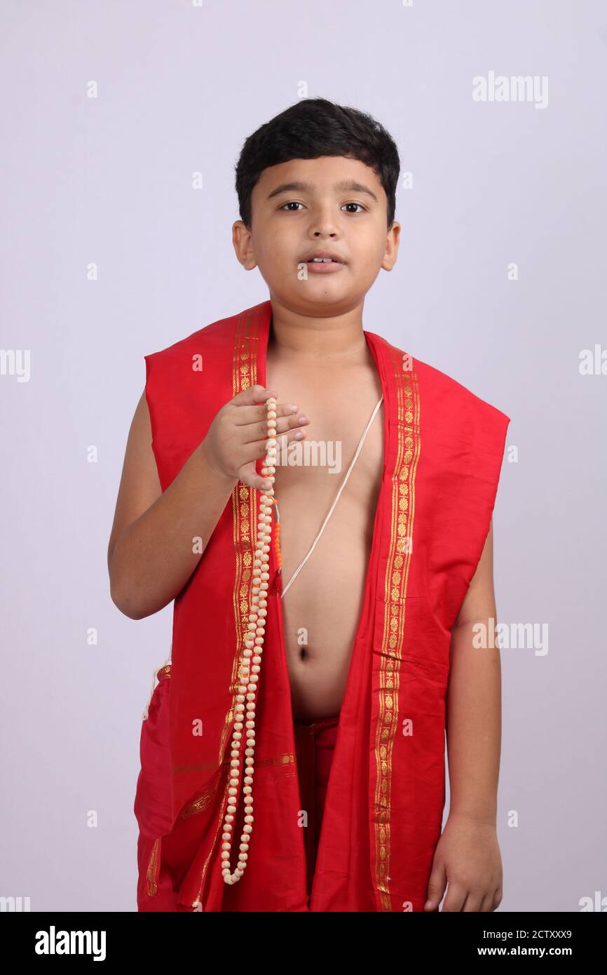 Niedlichen Jungen in indischen ethnischen tragen chanting Gottes Namen / jaap. Mit Rosenkranz Zeichenfolge Gebet Perlen oder japamala. Stockfoto