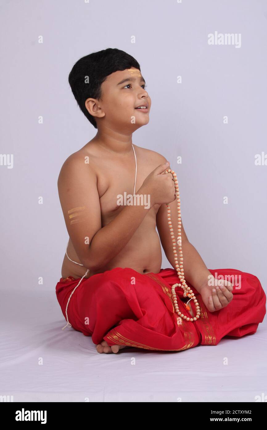 Junge in indischen ethnischen tragen beten gott. Namaste Pose Stockfoto