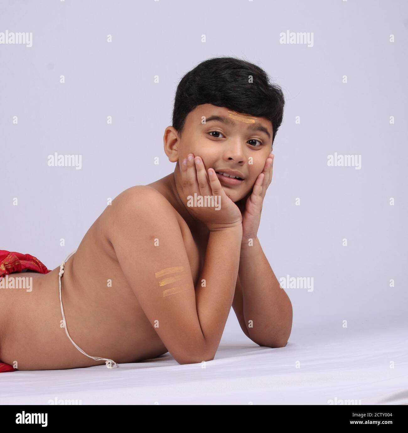 Junge indische Jungen in ethnischen tragen Verlegung oder genießen Freizeit auf weißem Hintergrund. Stockfoto
