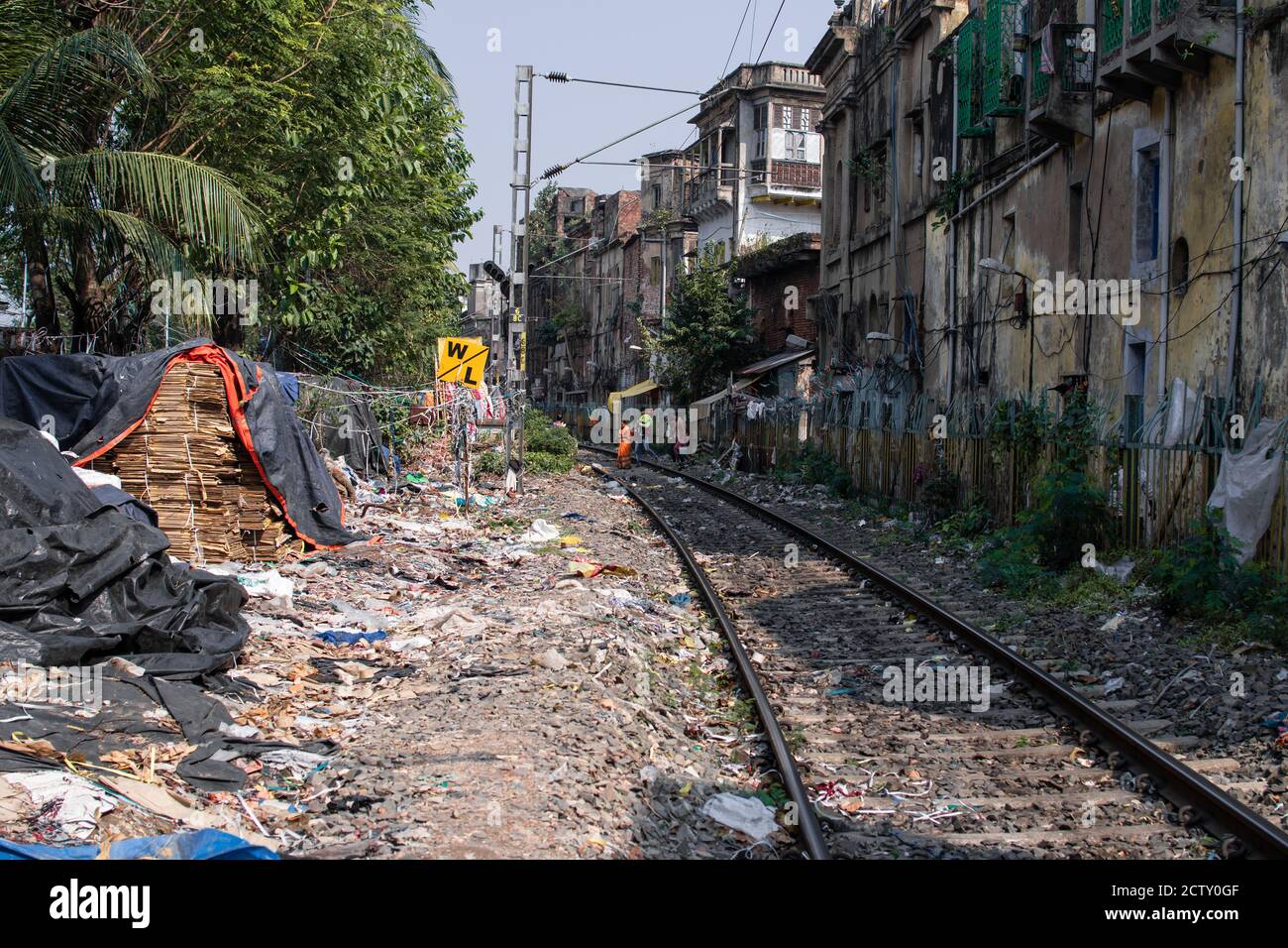 Kolkata, Indien - 2. Februar 2020: Am 2. Februar 2020 durchqueren einige nicht identifizierte Menschen die aktive Eisenbahn in den Slums in Kolkata, Indien Stockfoto
