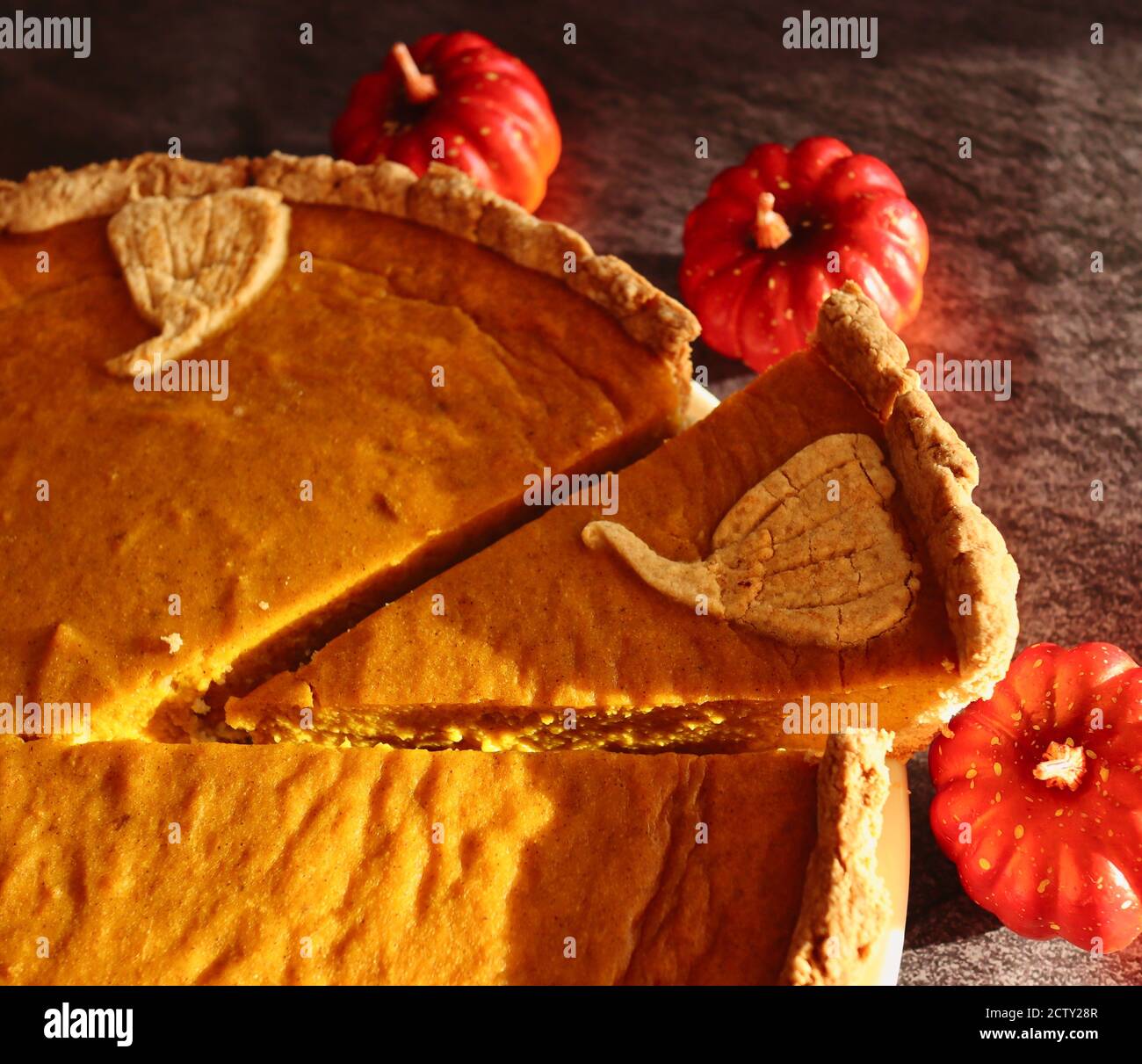 Nahaufnahme von Kürbiskuchen mit kleinen dekorativen künstlichen Kürbissen. Herbst Vibes mit traditionellen glutenfreien Kuchen. Stockfoto
