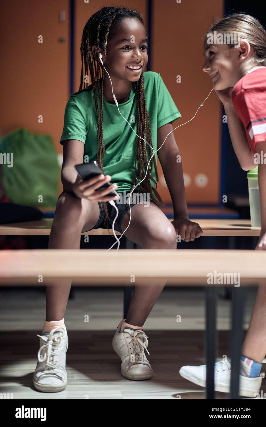 Die kleinen Fußballspieler hören die Musik in einem Umkleideraum vor dem Training Stockfoto