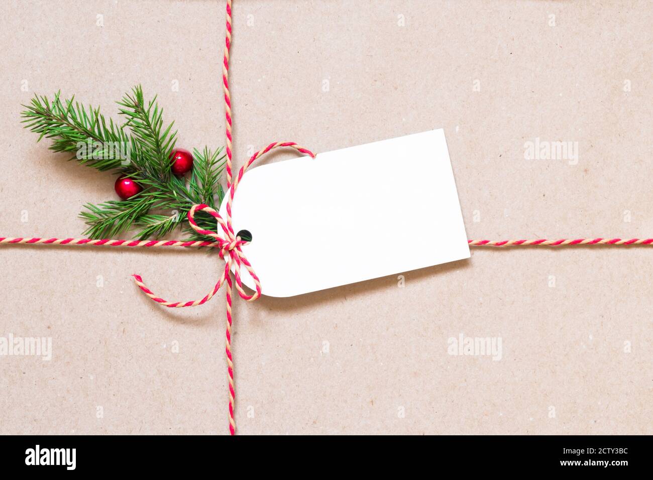 Geschenkanhänger und Tannenzweig auf braunem Papier. Weihnachten und Neujahr Hintergrund mit Kopierplatz. Stockfoto