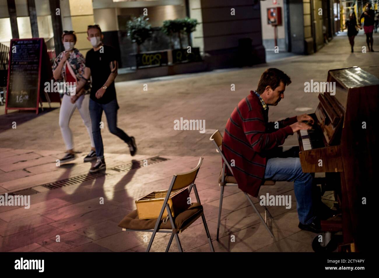 25. September 2020, Barcelona, Katalonien, Spanien: Menschen mit Gesichtsmasken laufen an einem Mann vorbei, der in der Innenstadt von Barcelona Klavier spielt. Am Donnerstagabend meldete das spanische Gesundheitsministerium 10,653 neue Infektionen, womit die offizielle Zahl seit Beginn der Pandemie auf mehr als 700,000 gestiegen ist. Quelle:Jordi Boixareu/Alamy Live News Stockfoto