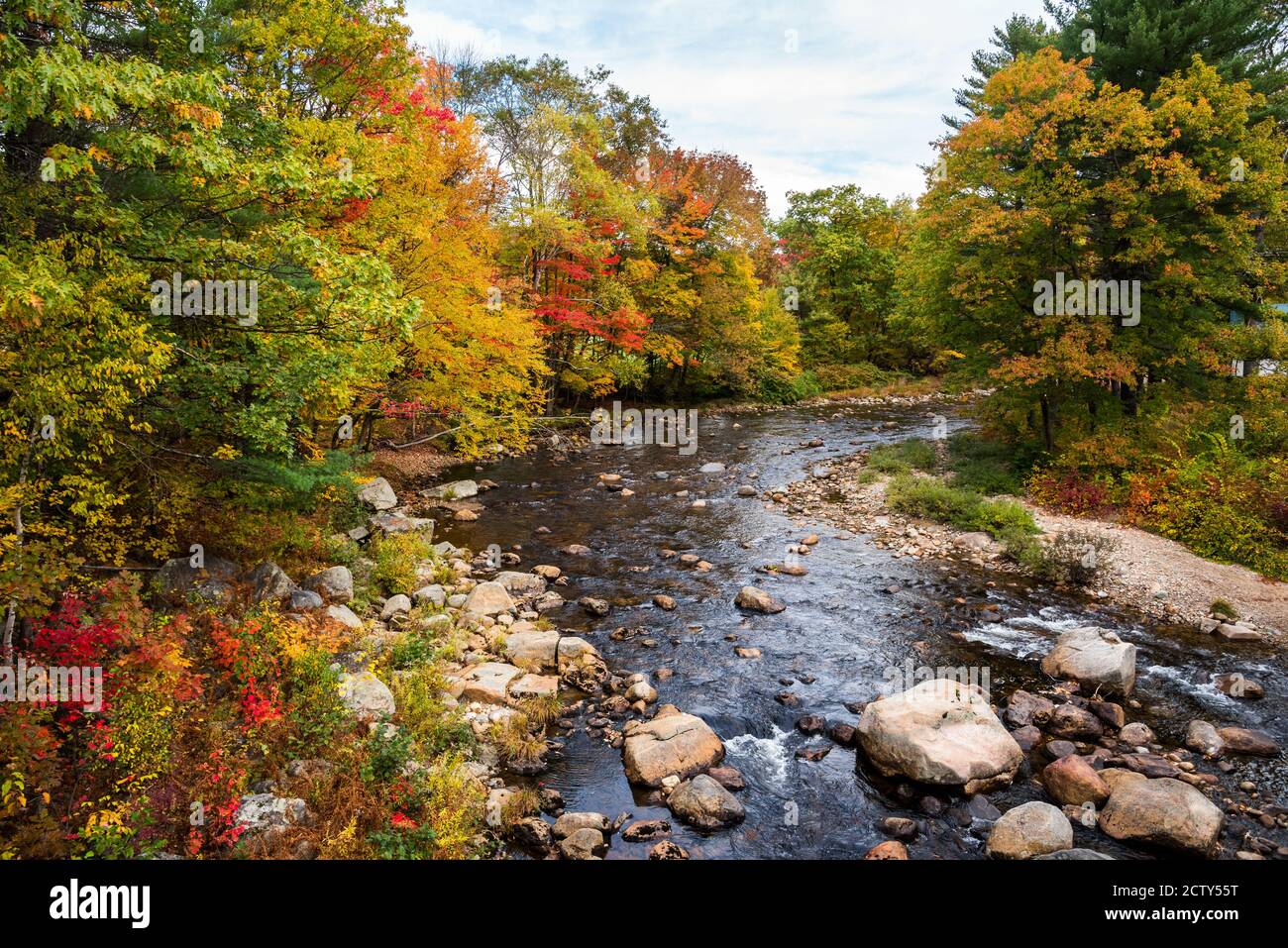 Atemberaubende Herbstfarben entlang Bergfluss auf einem teilweise bewölkt Herbsttag Stockfoto