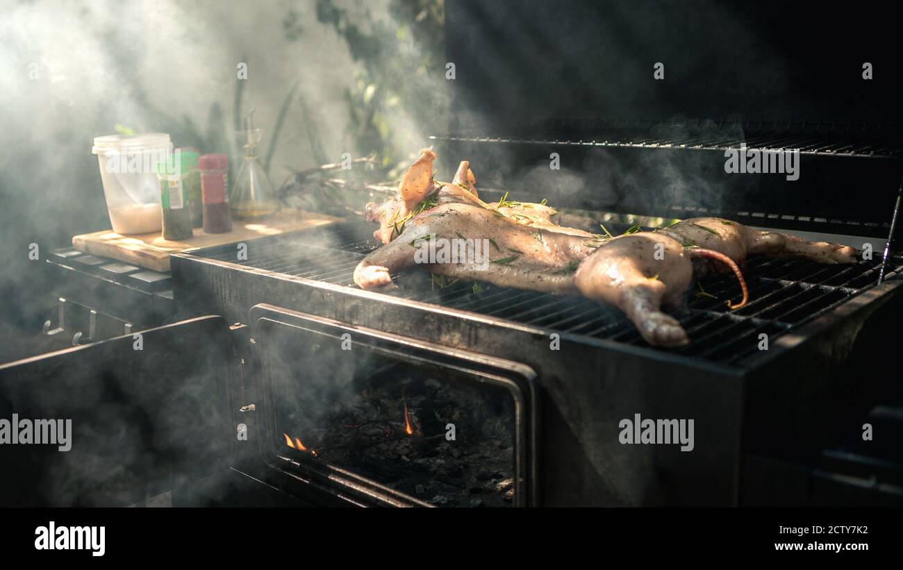 Leckeres Schweinefleisch auf einem Grill. Nahaufnahme des ganzen Schweins gekochtes gegrilltes Fleisch in BBQ von Gartenhaus in den Ferien. Knusprig gebratenes Ferkel am Spieß Stockfoto