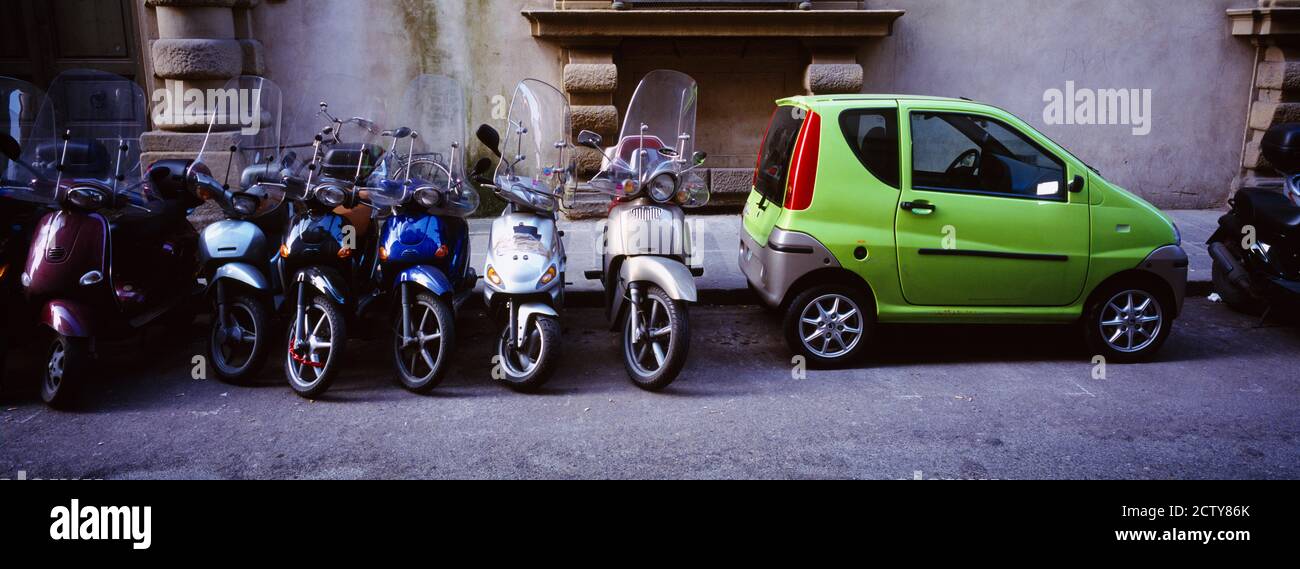 Motorroller mit einem Auto in einer Straße, Florenz, Italien geparkt Stockfoto