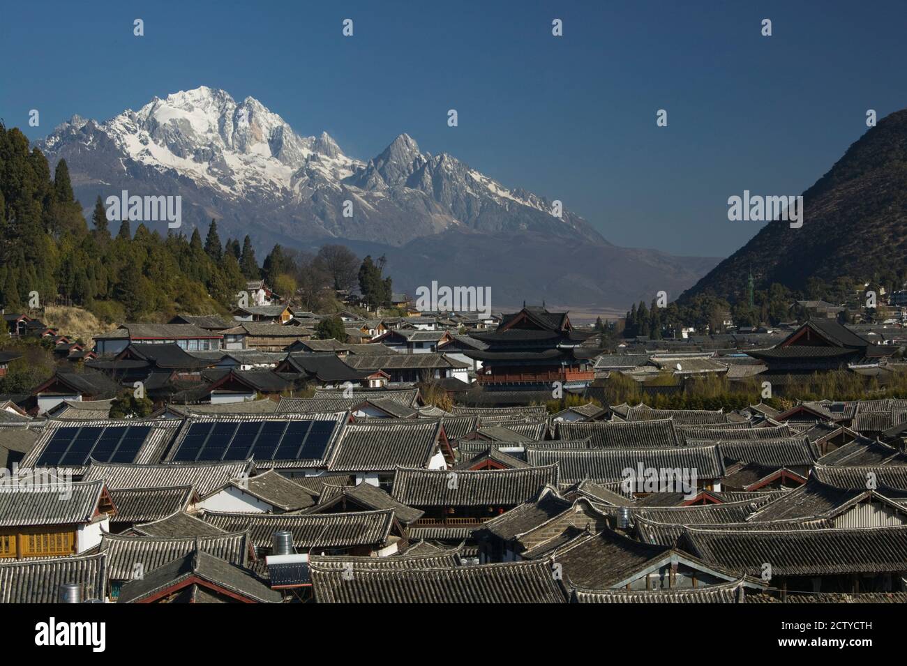 Hochwinkelansicht der Häuser mit Jadedrachen Schneeberg im Hintergrund, Altstadt, Lijiang, Provinz Yunnan, China Stockfoto