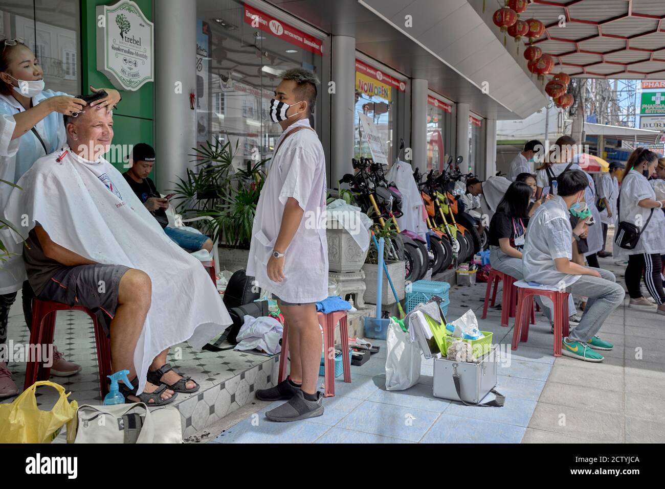 Straßenhaarschnitt. Business-Förderung eines lokalen Thailand Friseursalon mit Menschen bekommen einen kostenlosen Haarschnitt. Straßenbarbier Stockfoto