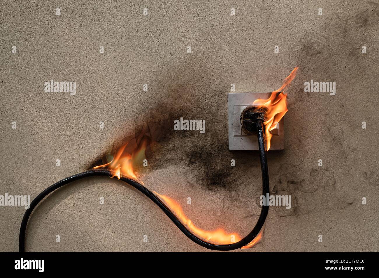 Bei Feuer elektrische Kabelstecker Buchse an der Betonwand freiliegenden Beton Hintergrund mit Kopierraum Stockfoto