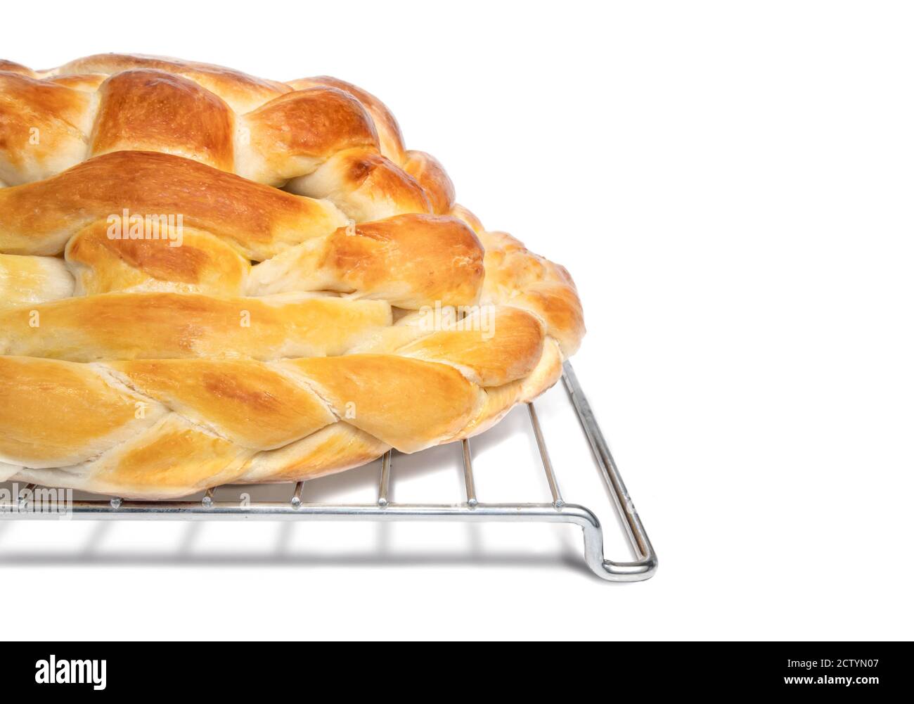 Geflochtenes Brot auf Kühlgestell. Hefeebrot Zopf oder Butterzopf. Oder Challah Brot. Dekorativer Mittelpunkt. Isoliert auf Weiß. Stockfoto