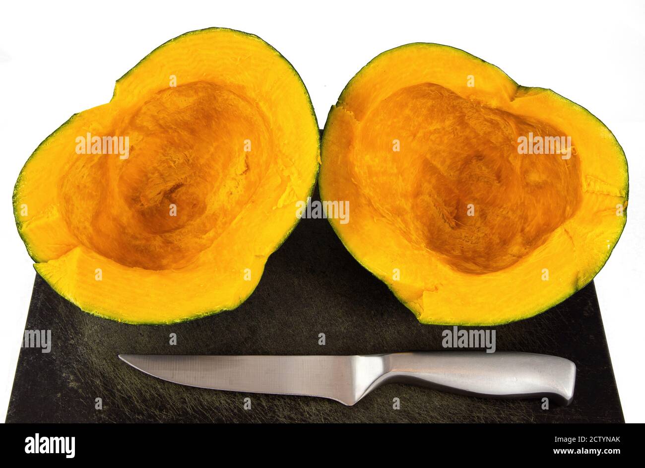 Buttercup Squash auf Schneidebrett mit Messer halbieren. Kabocha Squash, Turban Squash oder Cucurbita maxima. Orange süßes Fleisch. Stockfoto