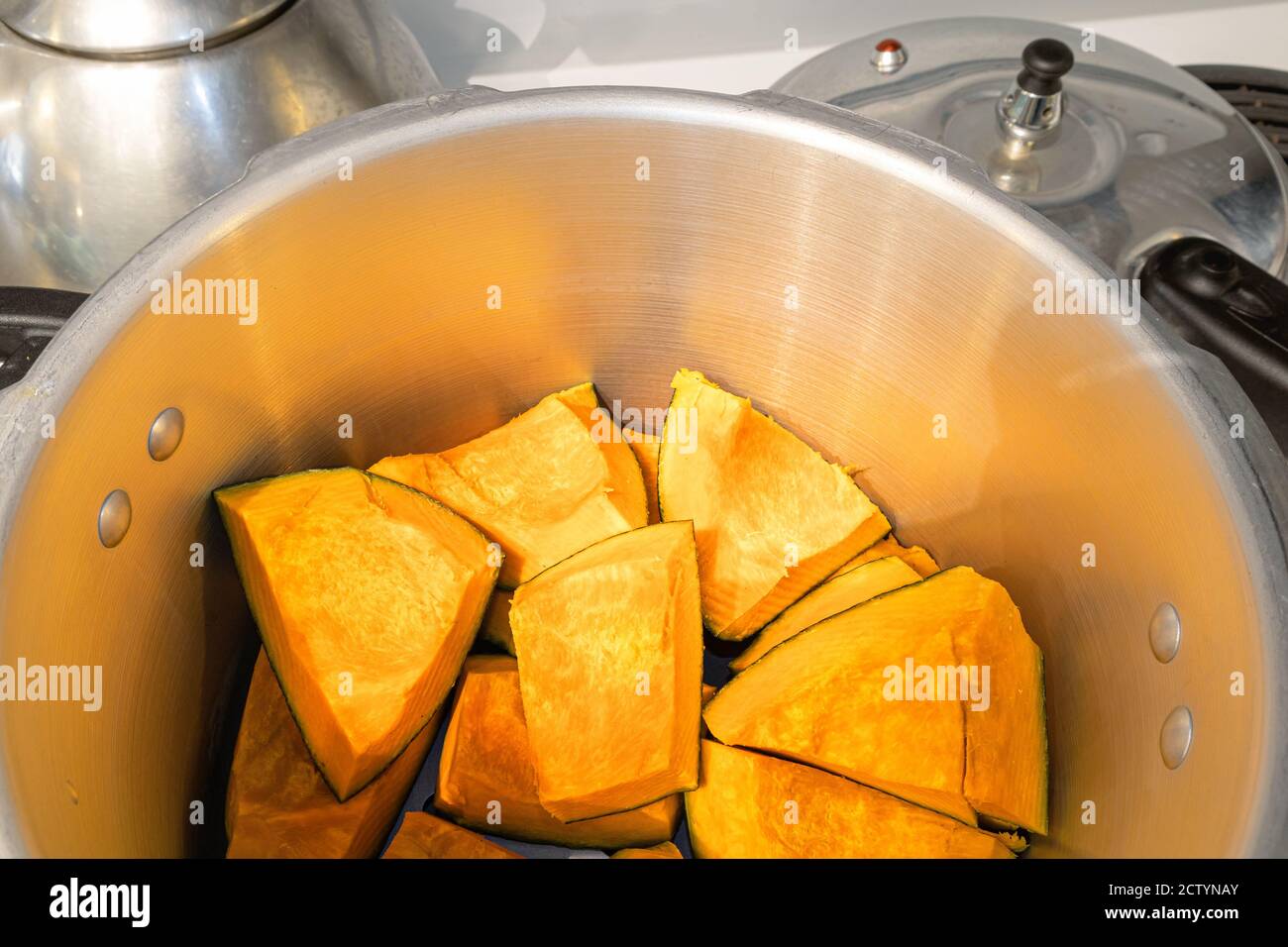 Buttercup-Squash-Stücke im Schnellkochtopf. Kabocha Squash, Turban Squash oder Cucurbita maxima. Orange süßes Fruchtfleisch, reich an Vitamin A und Ballaststoffen. Stockfoto