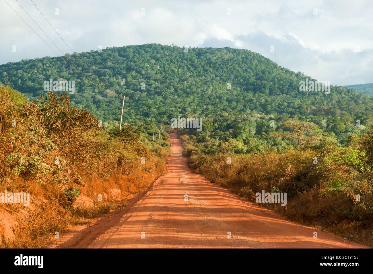 Ein Abschnitt der unbefestigten C106-Straße mit Shimba Hills im Hintergrund, Kenia, Ostafrika Stockfoto