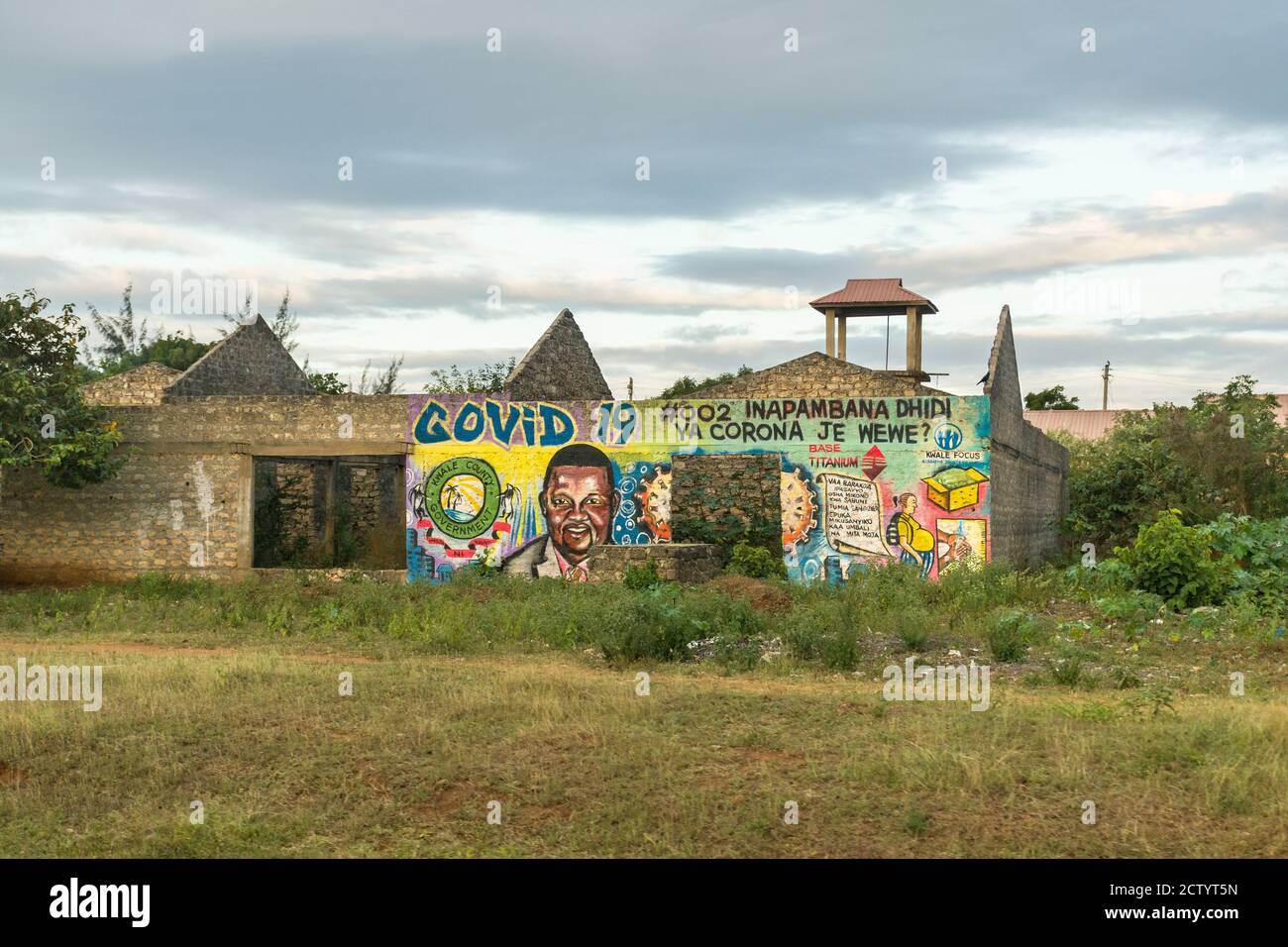 Ein teilweise gebautes Gebäude mit einem großen bemalten Regierungsgemälde, das vor Covid-19, Ukunda, Kenia, warnt Stockfoto
