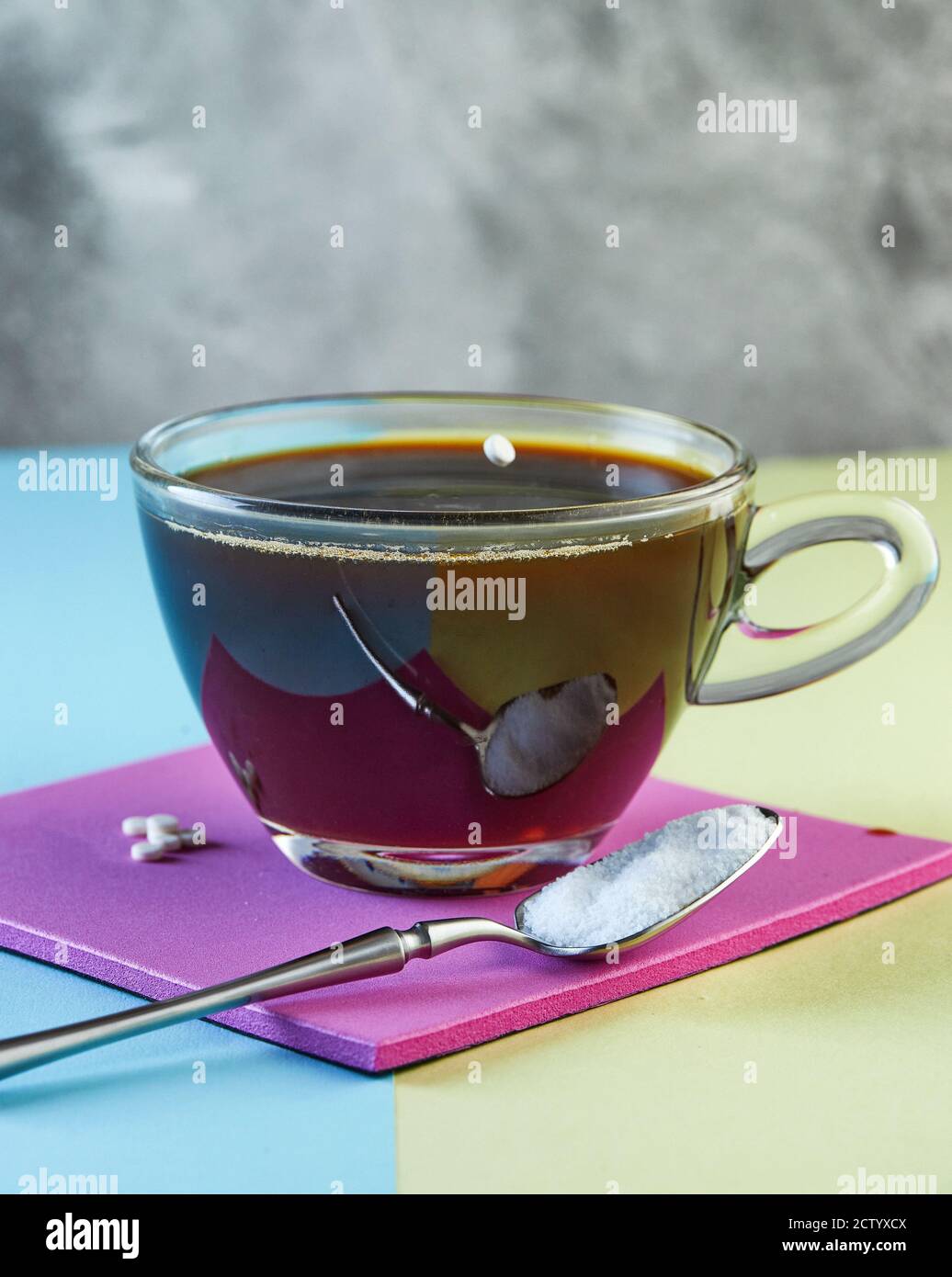 Pille von Zuckerersatz - Süßstoff fallen in eine Tasse Kaffee auf einem  lila Podium Stockfotografie - Alamy