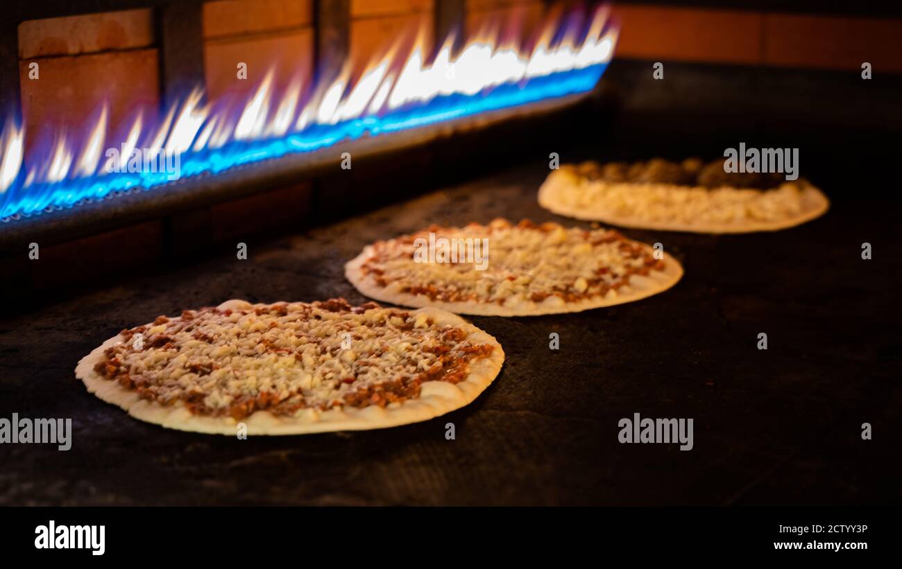 Hintergrundbild der Pizzaproduktion in einem heißen Ofen.Pizzaproduktion Stockfoto