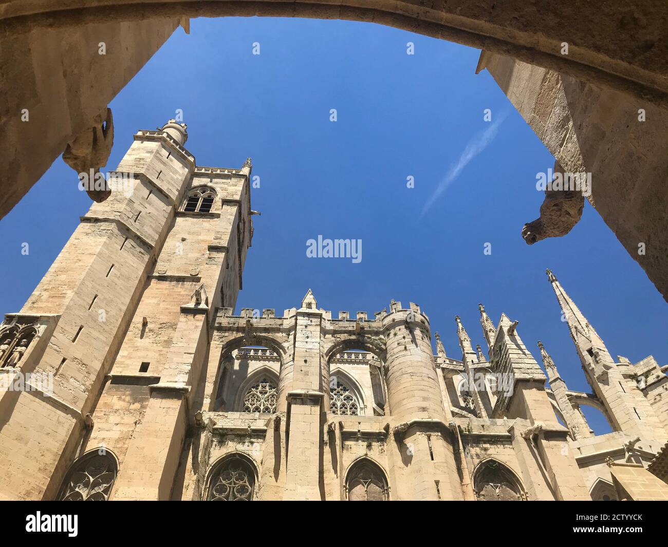 Das gotische Kathedtral in Narbonne, Frankreich mit seinen vielen Turmspitzen und dem Hauptuhrturm links aus der Wurmperspektive Stockfoto