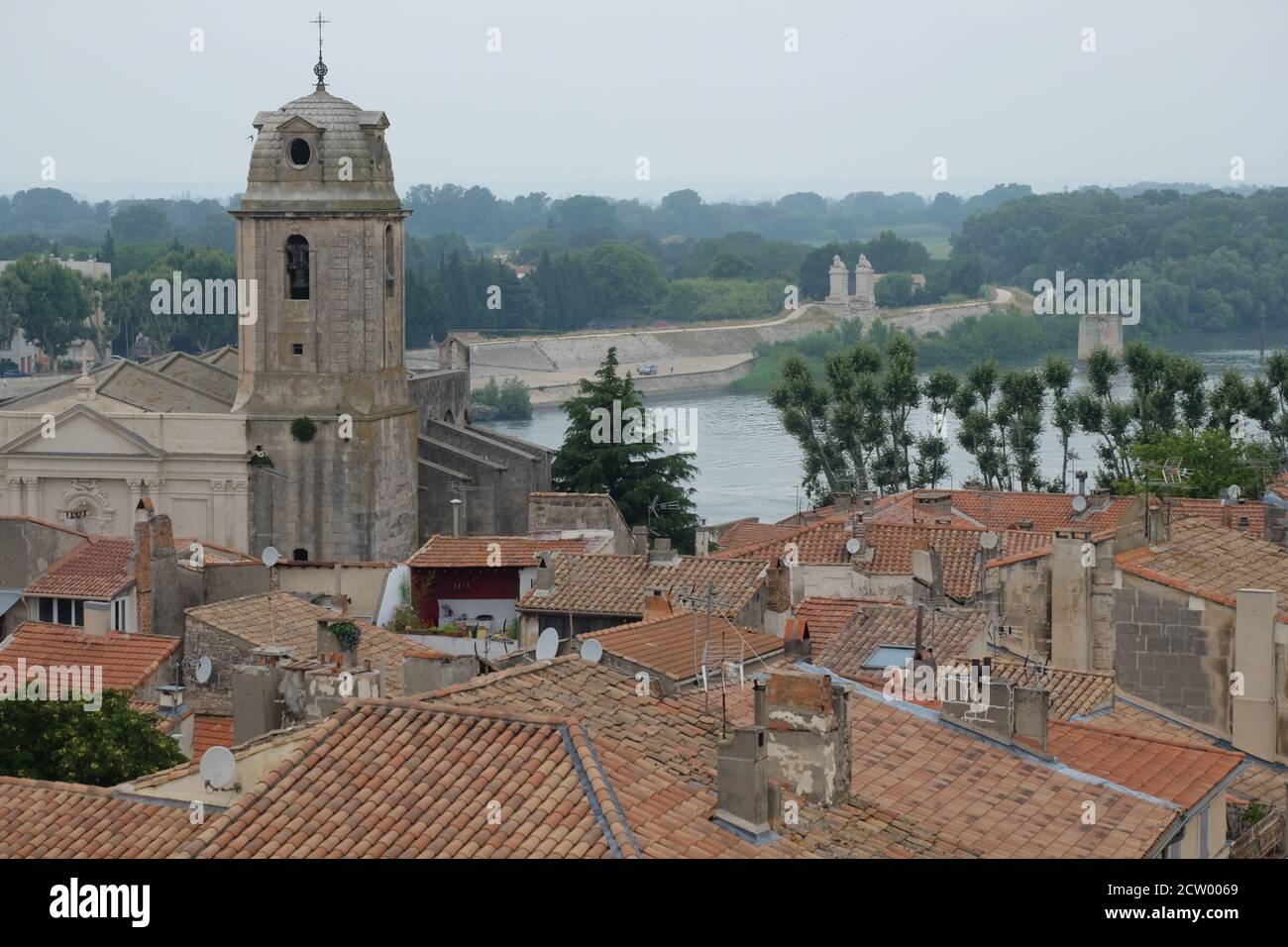 Das mittelalterliche Stadtzentrum von Arles in Südfrankreich mit Ein alter malerischer Kirchturm und die Rhone Der Hintergrund Stockfoto