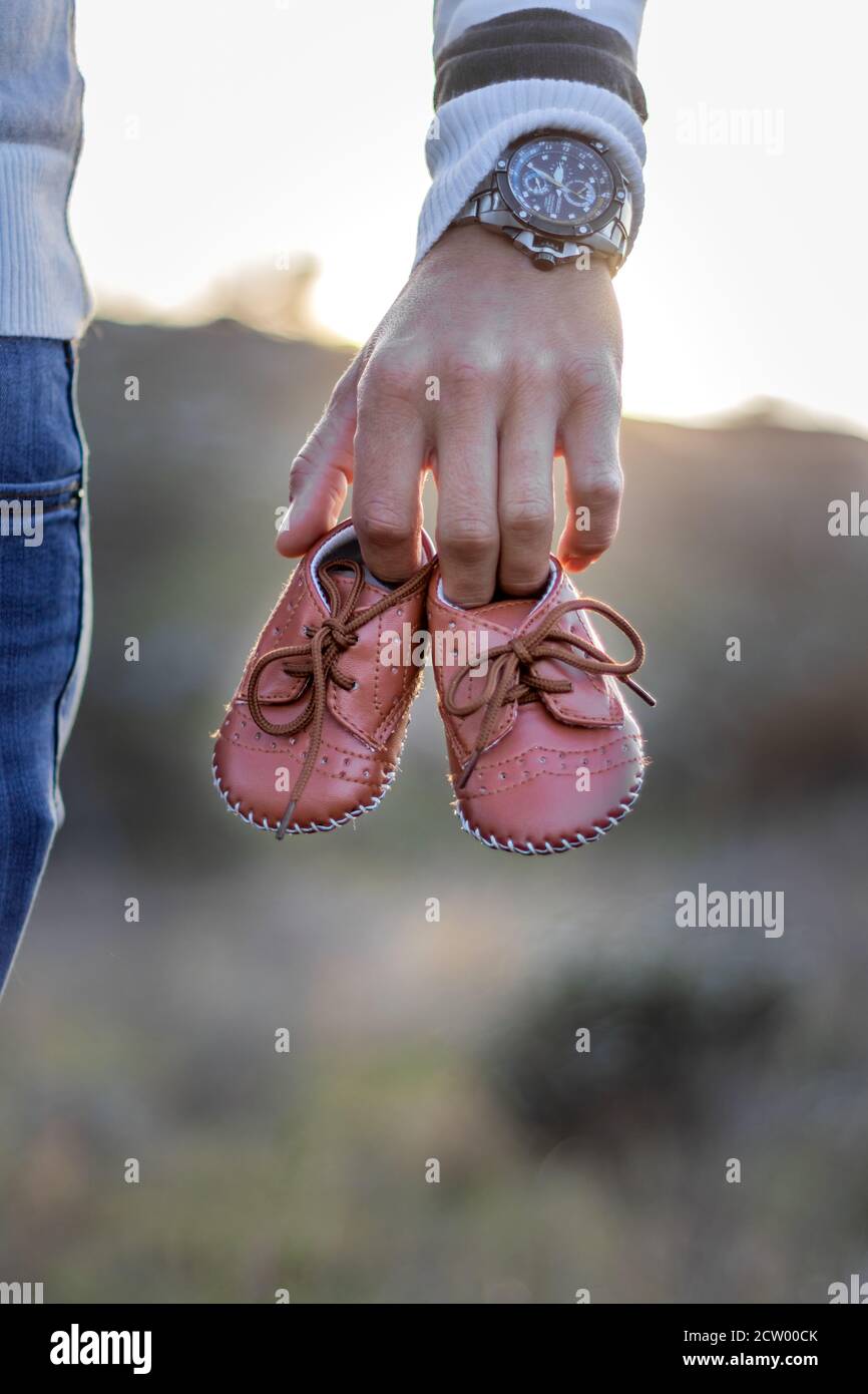 Mutterschaft Foto-Shooting, ein Vater hält die neuen Babys Schuhe in den Händen, Kapstadt, Südafrika Stockfoto