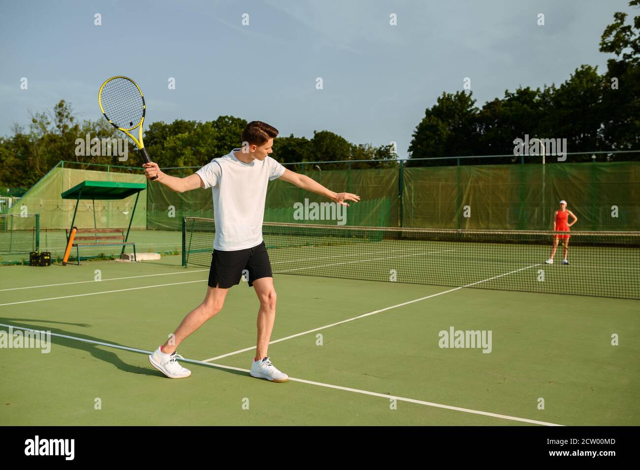 Männlicher Tennisspieler mit Schläger trifft den Ball Stockfoto