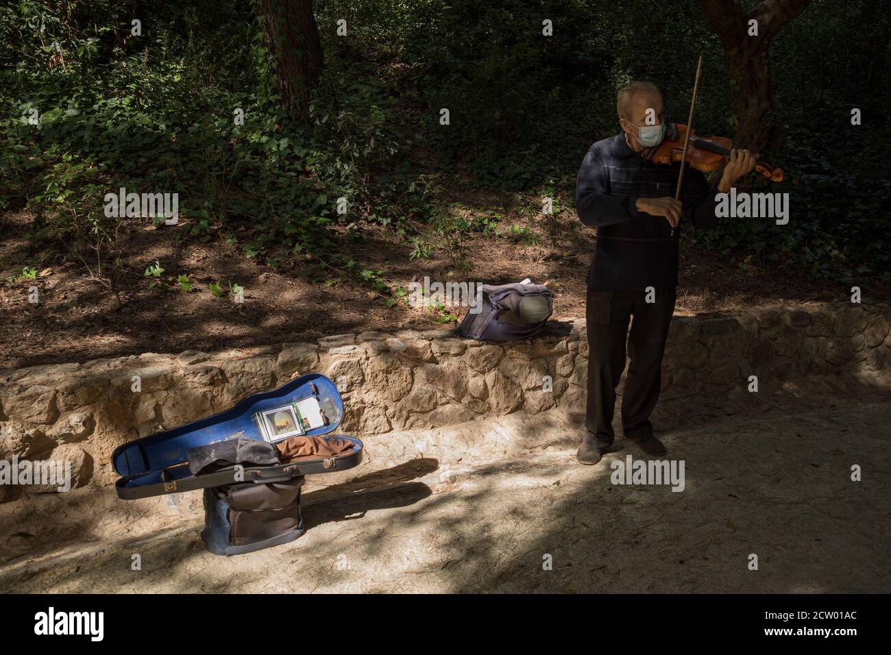 Barcelona. September 2020. Ein Musiker mit Gesichtsmaske spielt am 25. September 2020 die Geige im Park Güell in Barcelona, Spanien. Quelle: Joan Gosa/Xinhua/Alamy Live News Stockfoto