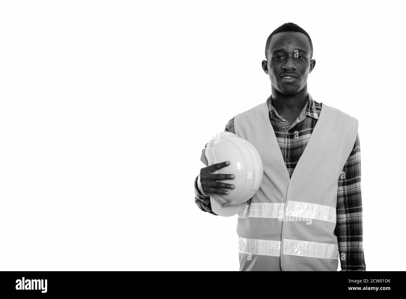 Studio shot der Jungen glücklich schwarzen afrikanischen Mann Bauarbeiter lächelnd, während sie Schutzhelm Stockfoto
