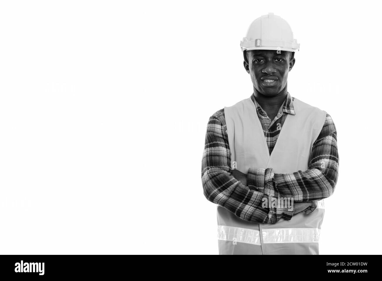Studio shot der Jungen glücklich schwarzen afrikanischen Mann Bauarbeiter lächelnd mit gekreuzten Armen Stockfoto