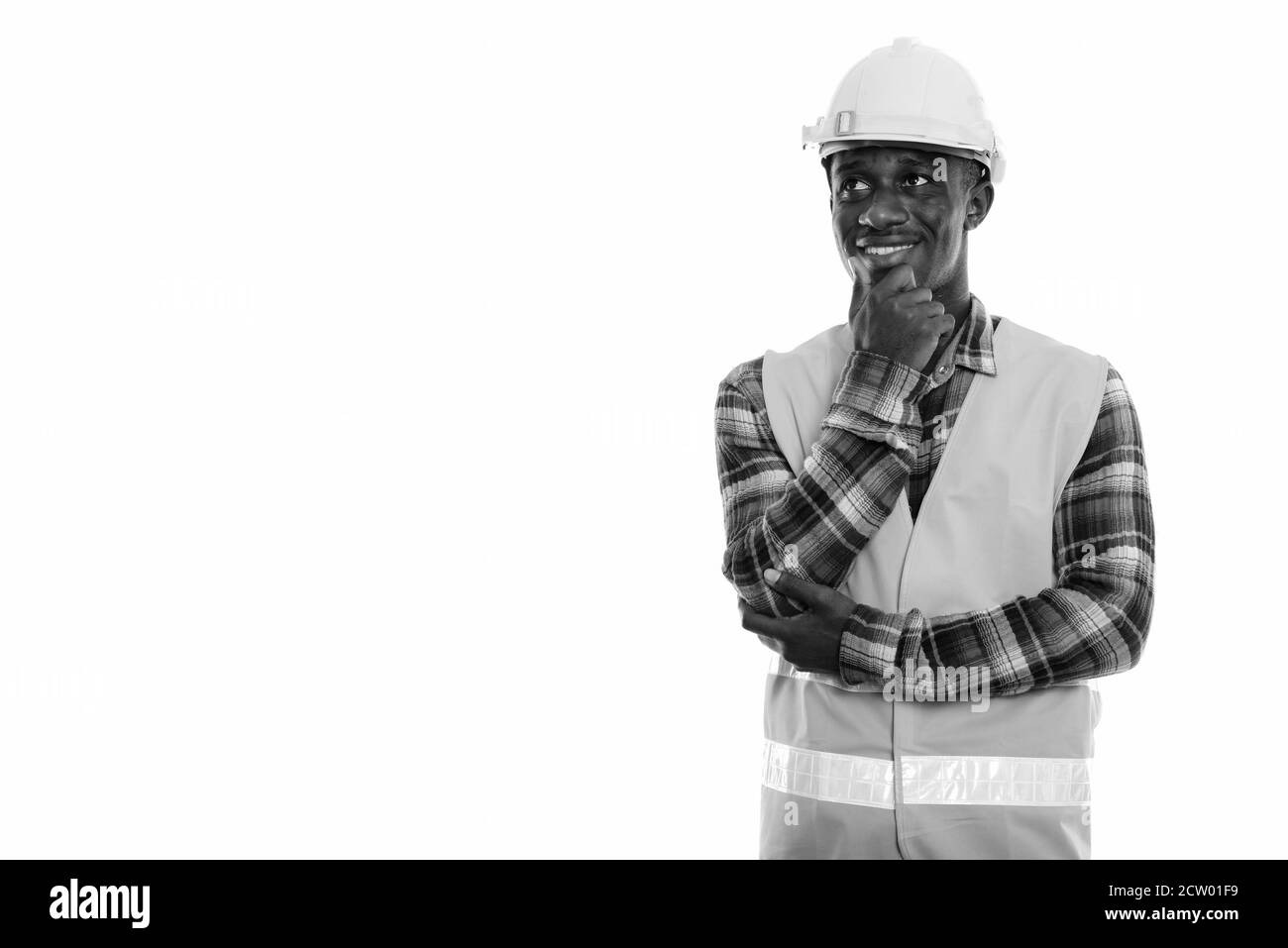Studio shot der Jungen glücklich schwarzen afrikanischen Mann Bauarbeiter lächeln und denken beim Suchen Stockfoto