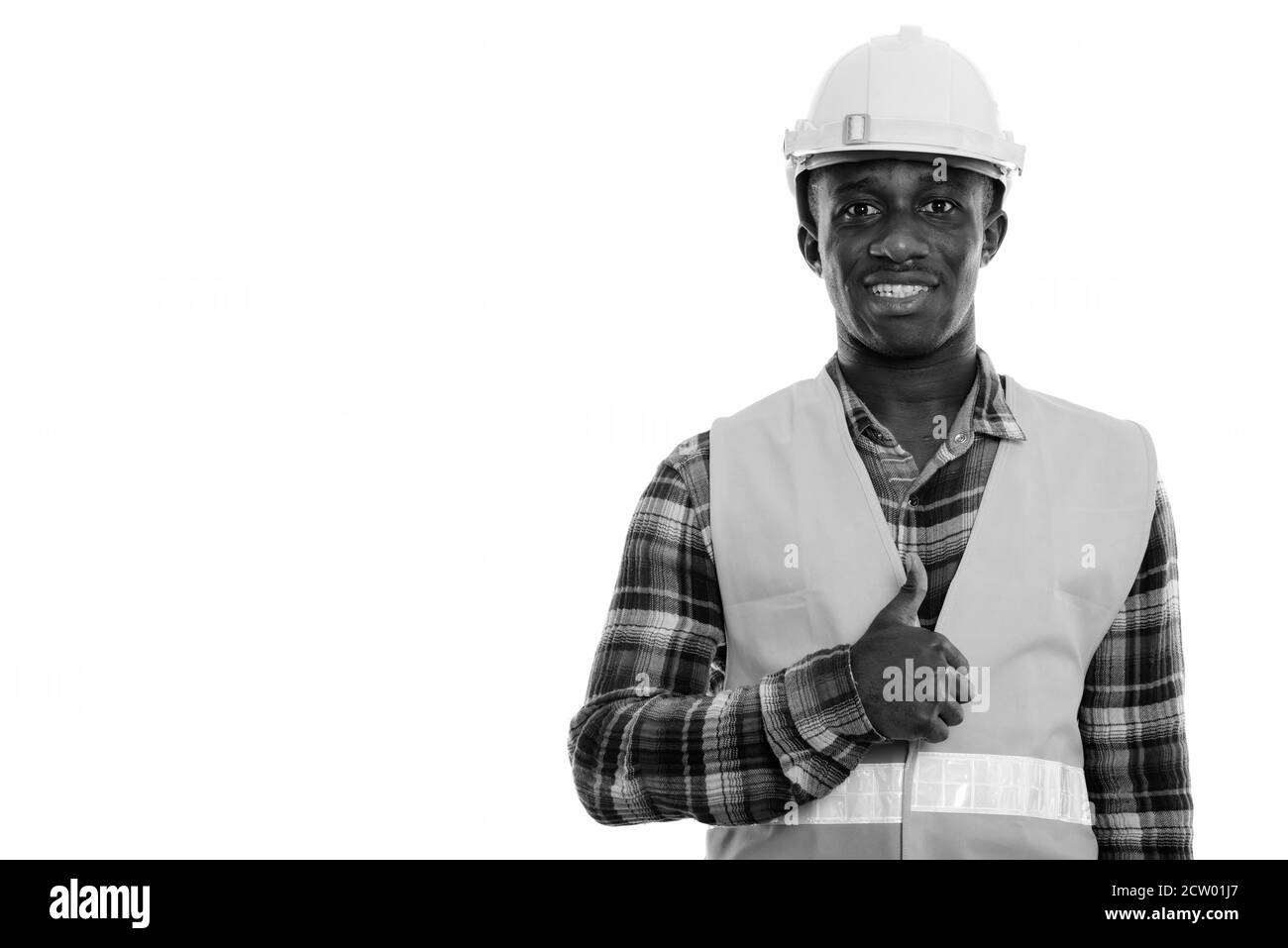 Studio shot der Jungen glücklich schwarzen afrikanischen Mann Bauarbeiter lächelnd während Daumen hoch geben Stockfoto