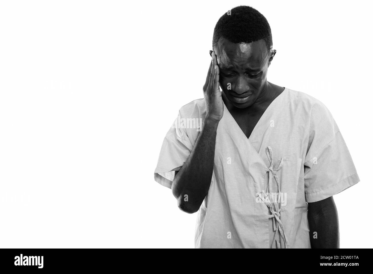 Studio shot von jungen schwarzen afrikanischen Mann Patienten traurig und wies mit der Hand auf dem Kopf Stockfoto