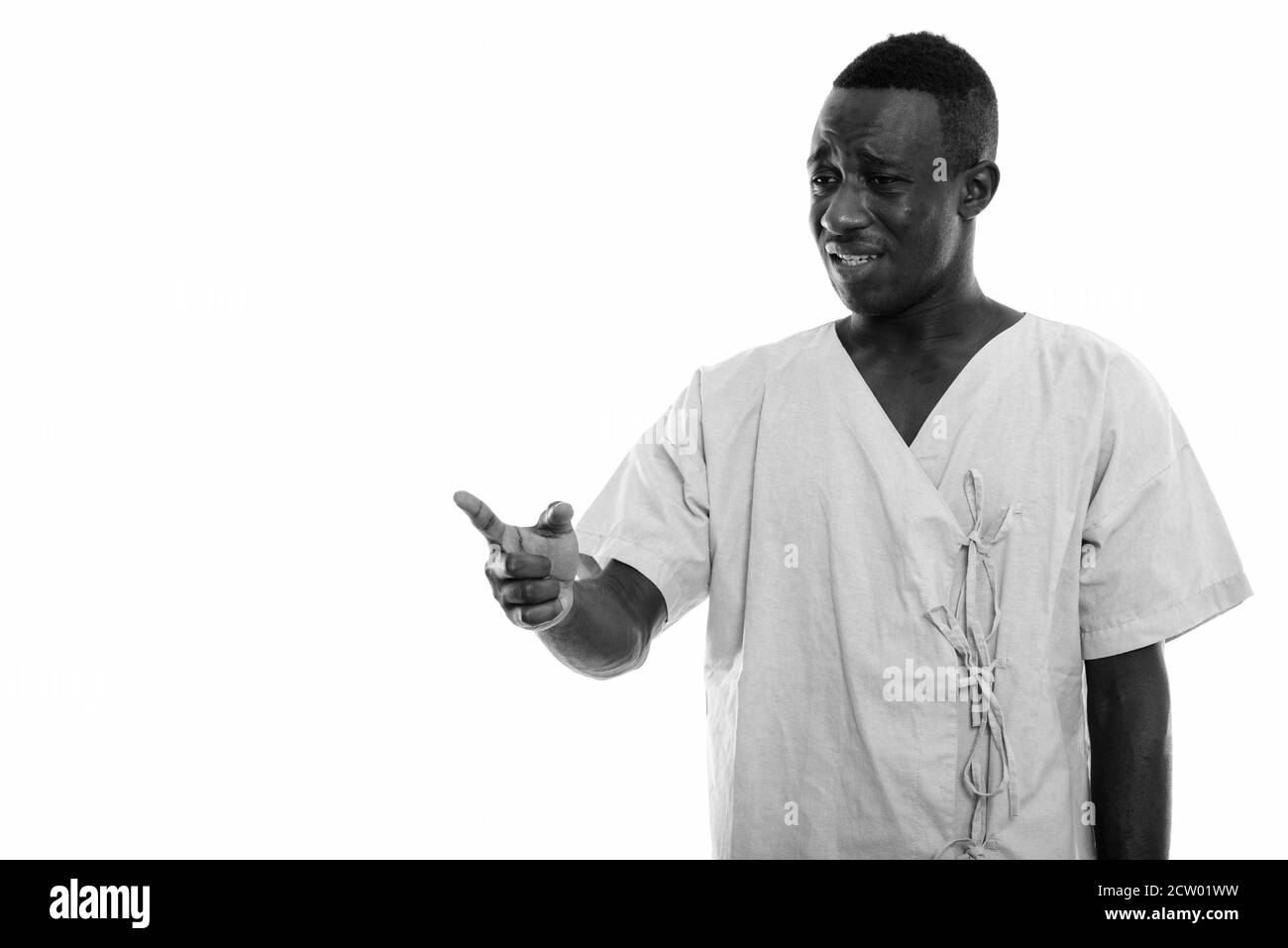 Studio shot von jungen schwarzen afrikanischen Mann Patienten traurig während Zeigefinger auf Distanz Stockfoto