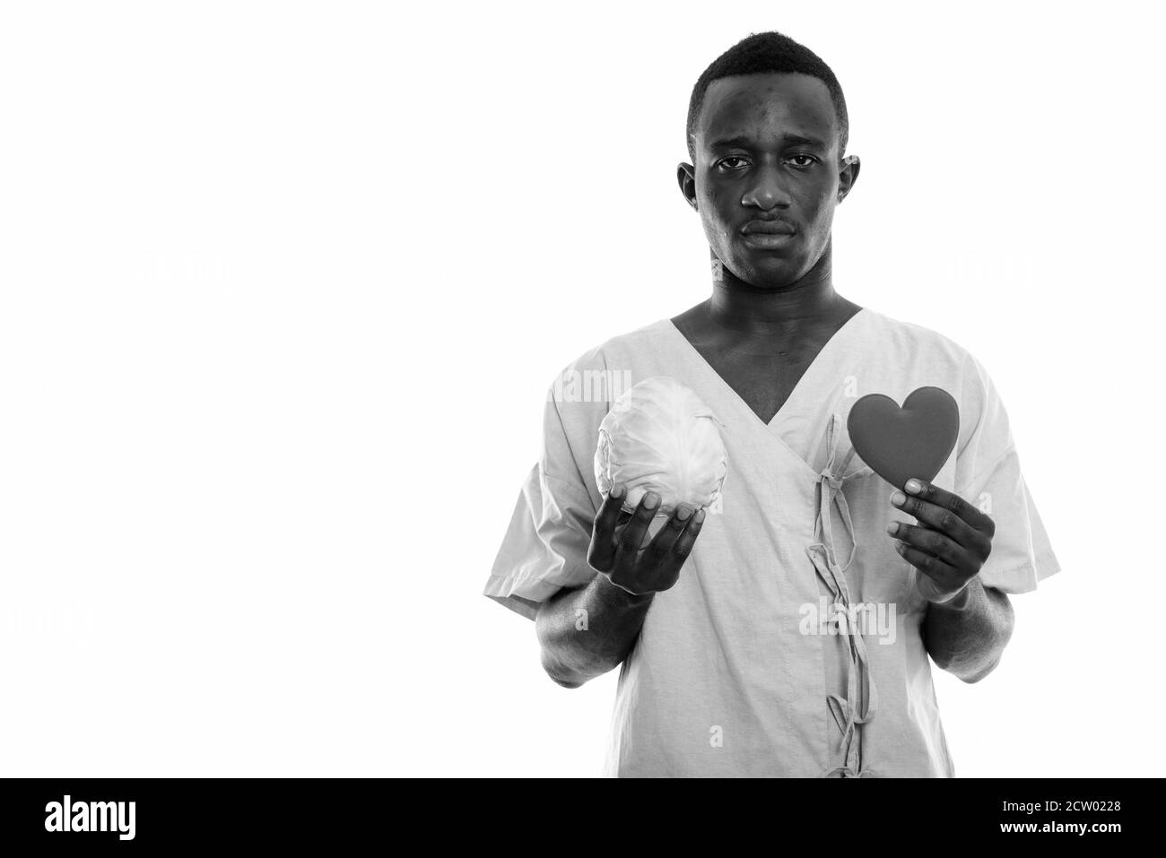 Studio Schuss von jungen schwarzen afrikanischen Mann Patient hält Kohl Und Herz Stockfoto