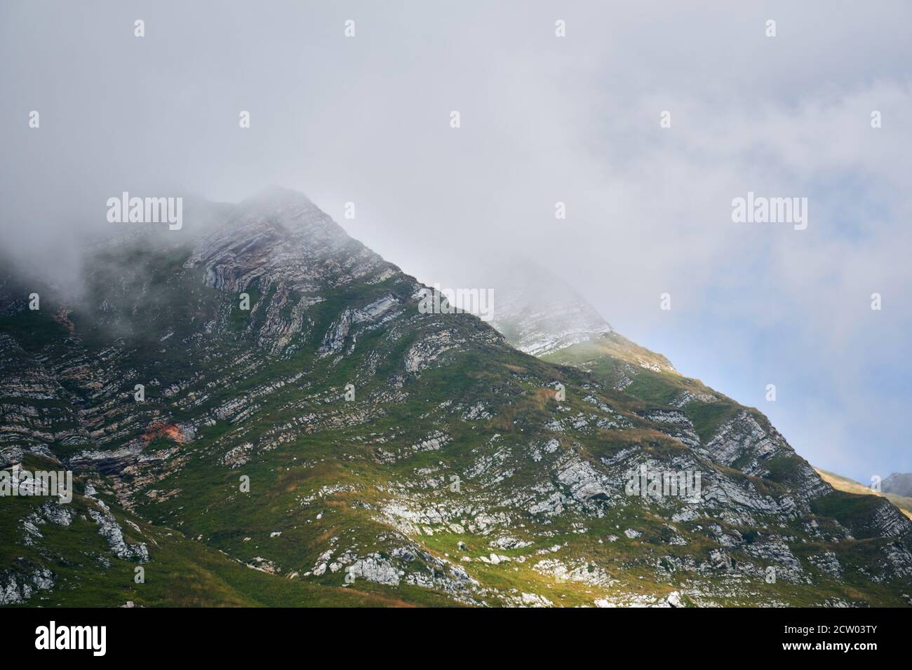 alpine Landschaft - die Gipfel der Gipfel sind versteckt Durch Wolken, durch die die Sonne scheint Stockfoto alpine Landschaft - die Gipfel der Gipfel sind versteckt Durch Wolken, durch die die Sonne scheint Stockfoto