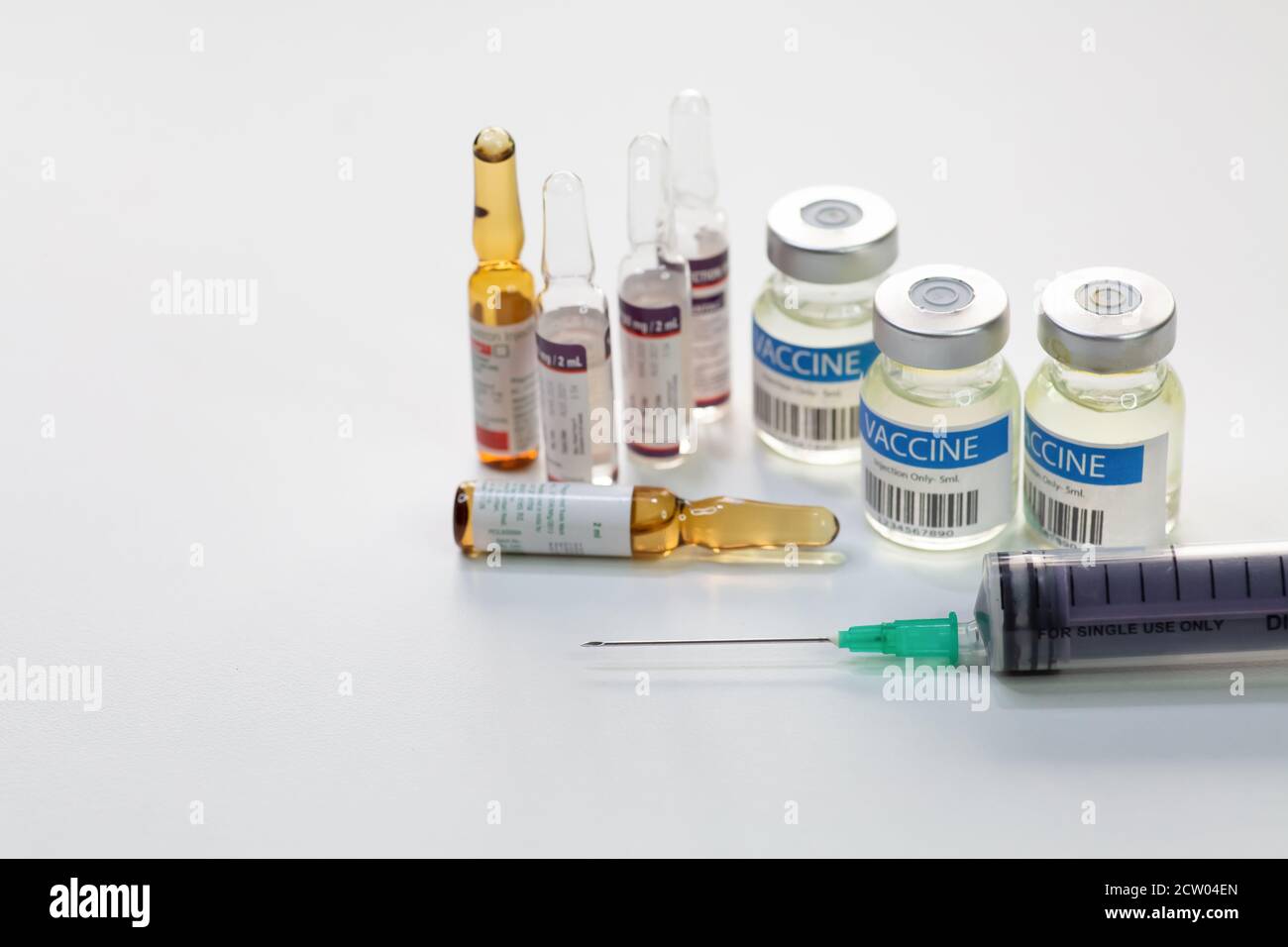 Hypodermische Spritzennadel mit Impfstoffflaschen und Injektionsfläschchen auf Weißer Hintergrund Stockfoto