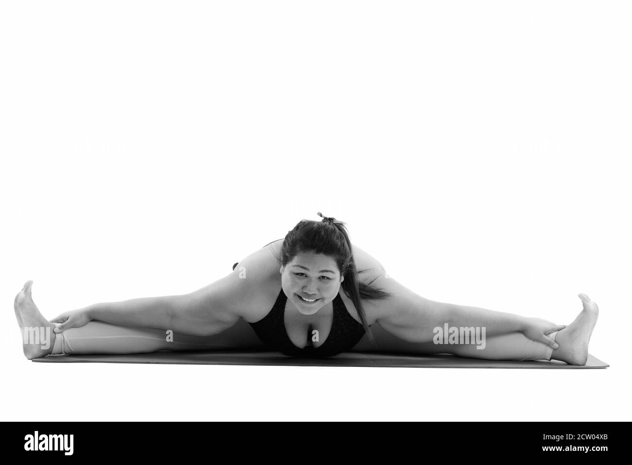 Studio shot der Jungen gerne Fett asiatische Frau lächelnd und teilen ihre Beine während Kamera suchen Stockfoto