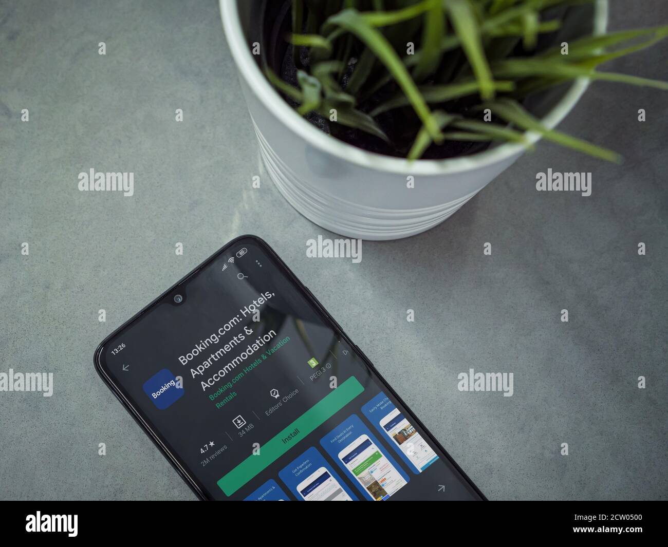 LOD, Israel - 8. Juli 2020: Moderner minimalistischer Büroarbeitsplatz mit schwarzem Smartphone mit Booking.com App Play Store-Seite auf Marmorhintergrund. Stockfoto