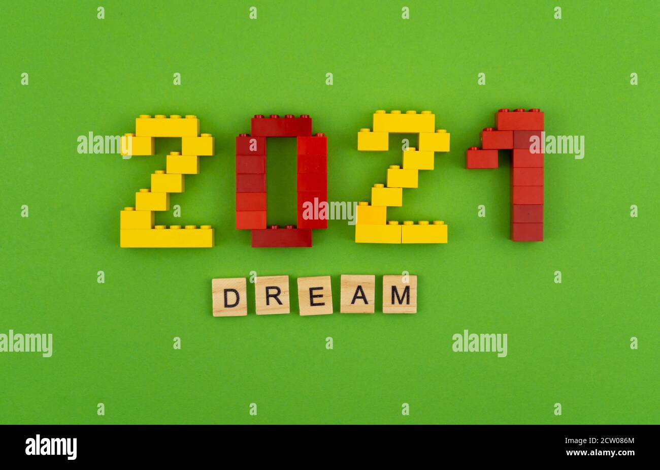 Der Satz Dream 2021 ist mit Holzbuchstaben auf grünem Hintergrund ausgekleidet. Abbildungen aus der Bauherrenansicht oben. Postkarte für Text an der richtigen Stelle. Flatlay Stockfoto