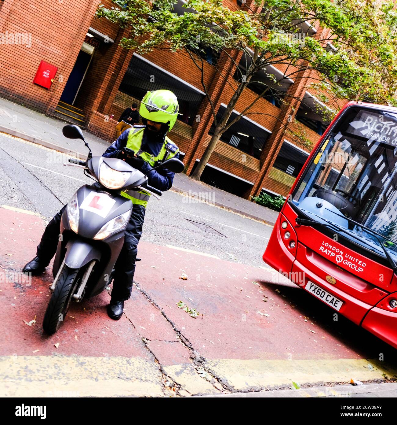 Verkehrswächter sitzt auf EINEM Motor Scooted vor Ein Transport für London Single Decker Red Bus Stockfoto