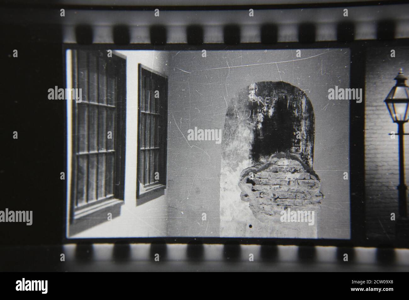 Feine Schwarz-Weiß-Fotografie der 70er Jahre des Putzes, der bis zur Ziegelwand durchbricht. Stockfoto