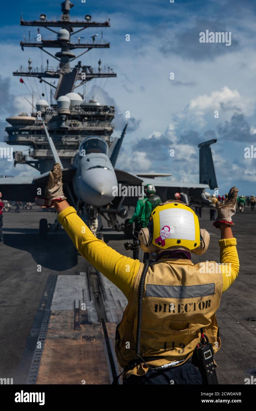 200915-N-ML137-1011 PHILIPPINISCHES MEER (SEPT 15, 2020) Aviation Boatswain's Mate (Handling) 3rd Class Charlotte Gray, aus Five Cities, Kalifornien, leitet einen F/A-18E Super Hornet, der an das Eagles of Strike Fighter Squadron (VFA) 115 auf dem Flugdeck des einzigen vorwärts eingesetzten Flugzeugträgers der Marine USS Ronald Reagan (CVN 76) angeschlossen ist. Zur Unterstützung von Valiant Shield 2020. Valiant Shield ist ein US-amerikanisches, zweijähriges Field Training Exercise (FTX) mit dem Schwerpunkt auf der Integration von gemeinsamen Schulungen in einer Blue-Water-Umgebung unter US-Streitkräften. Diese Schulung ermöglicht die praktische Erzielungsfähigkeit bei der Aufrechterhaltung gemeinsamer f Stockfoto
