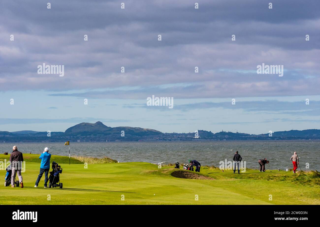 East Lothian, Schottland, Großbritannien, 26. September 2020. Wetter in Großbritannien: Golfer auf dem Craigielaw Golf Course sind trotz des starken Windes bei Sonnenschein mit Blick über den Firth of Forth der Skyline von Edinburgh in Kraft Stockfoto