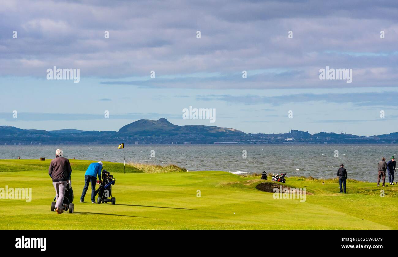 East Lothian, Schottland, Großbritannien, 26. September 2020. Wetter in Großbritannien: Golfer auf dem Craigielaw Golf Course sind trotz des starken Windes bei Sonnenschein mit Blick über den Firth of Forth der Skyline von Edinburgh in Kraft Stockfoto