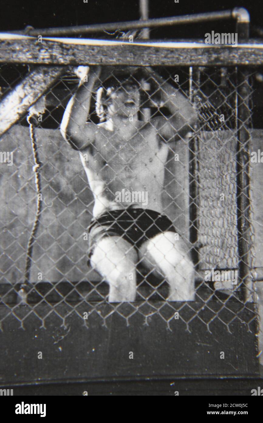 Feine Vintage-Schwarz-Weiß-Fotografie aus den 1970er Jahren eines jungen Mannes, der in einem Dunkeltank oder in einer Dunkelkabine sitzt. Stockfoto
