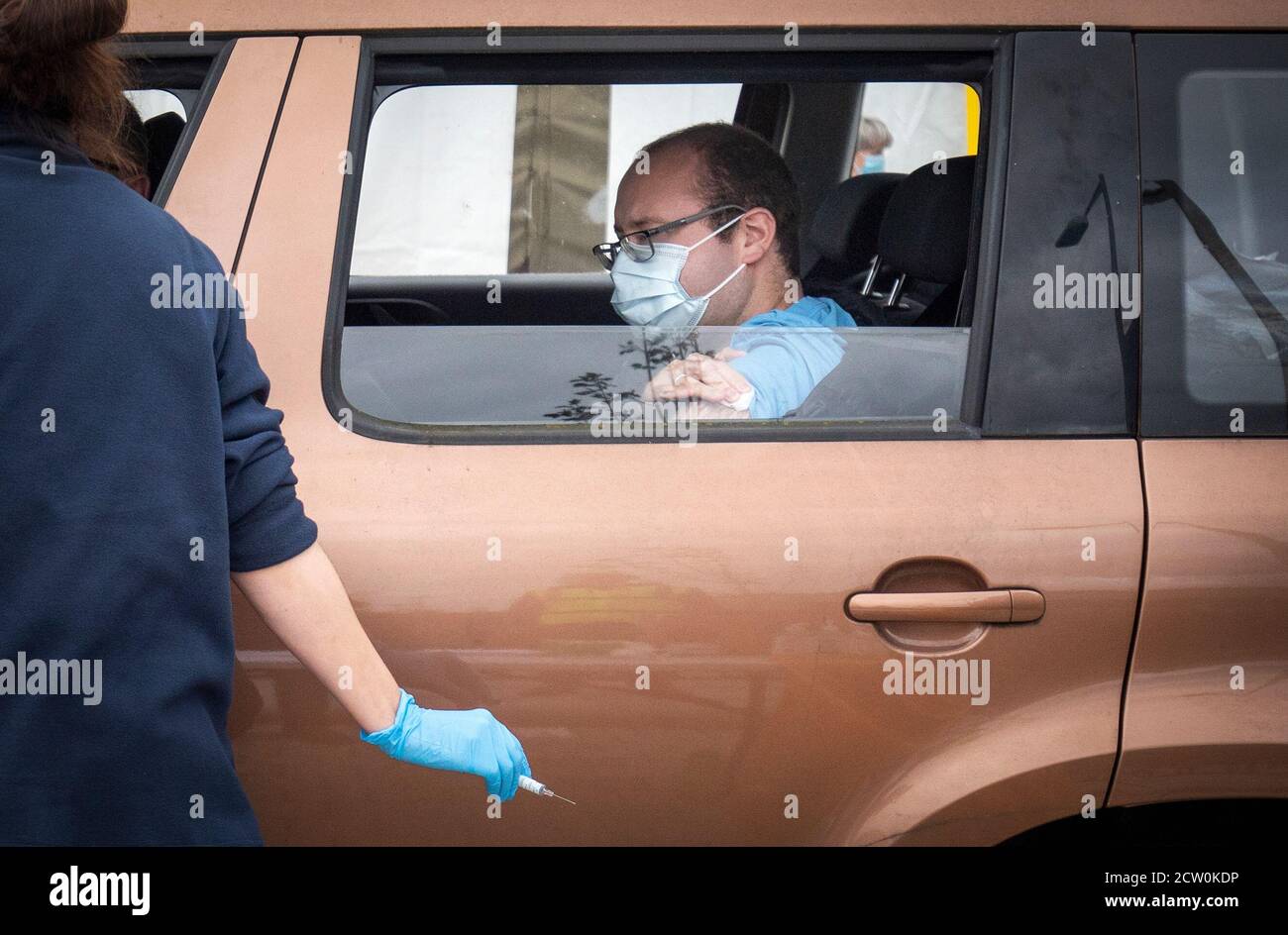 Ein Mitglied der Öffentlichkeit erhält einen Grippeimpfstoff saß in ihrem Auto in einer der neuen Drive-Thru-Grippe-Kliniken in Little France, Edinburgh. Stockfoto