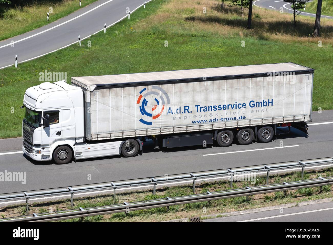 Scania LKW mit a.d.R. Transservice GmbH Curtainside Trailer auf der Autobahn. Stockfoto