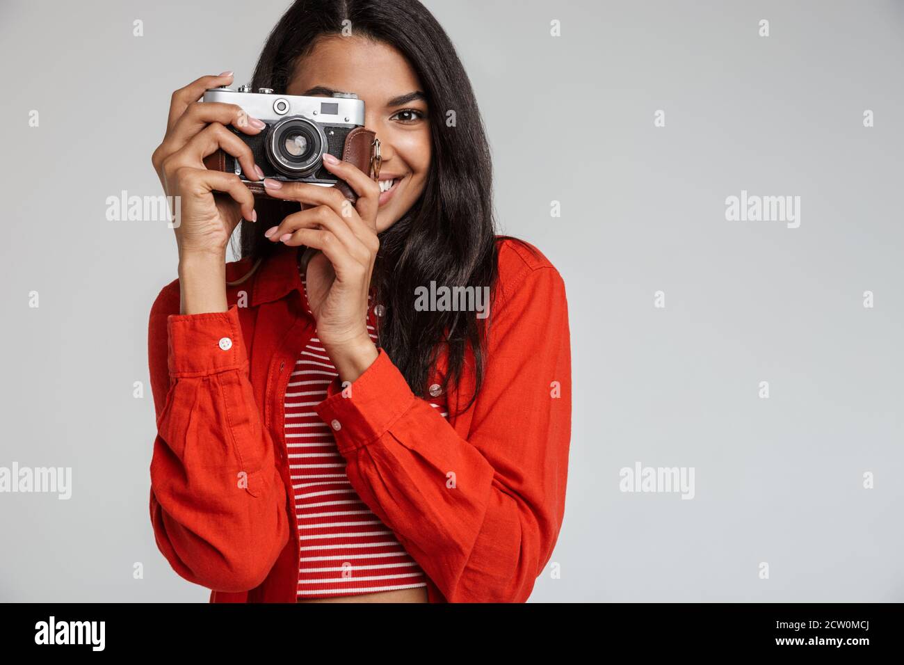 Porträt eines lächelnden hübschen afroamerikanischen Mädchen, das Foto Mit einer Kamera auf grauem Hintergrund isoliert Stockfoto