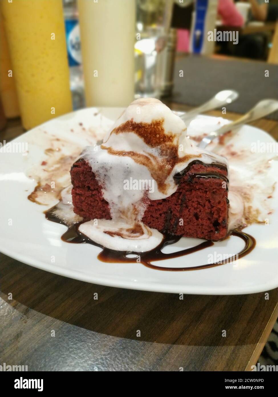 Eine klassische Kombination aus schmelzendem Vanilleeis auf dem doppelten Schokoladenbrownie. Stockfoto