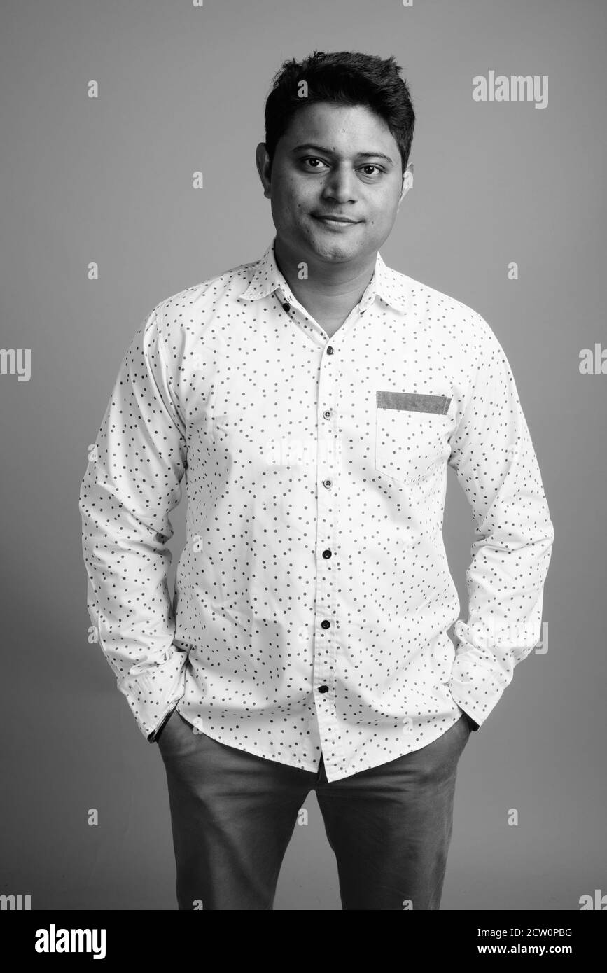 Porträt der jungen indischen Geschäftsmann gegen grauer Hintergrund Stockfoto