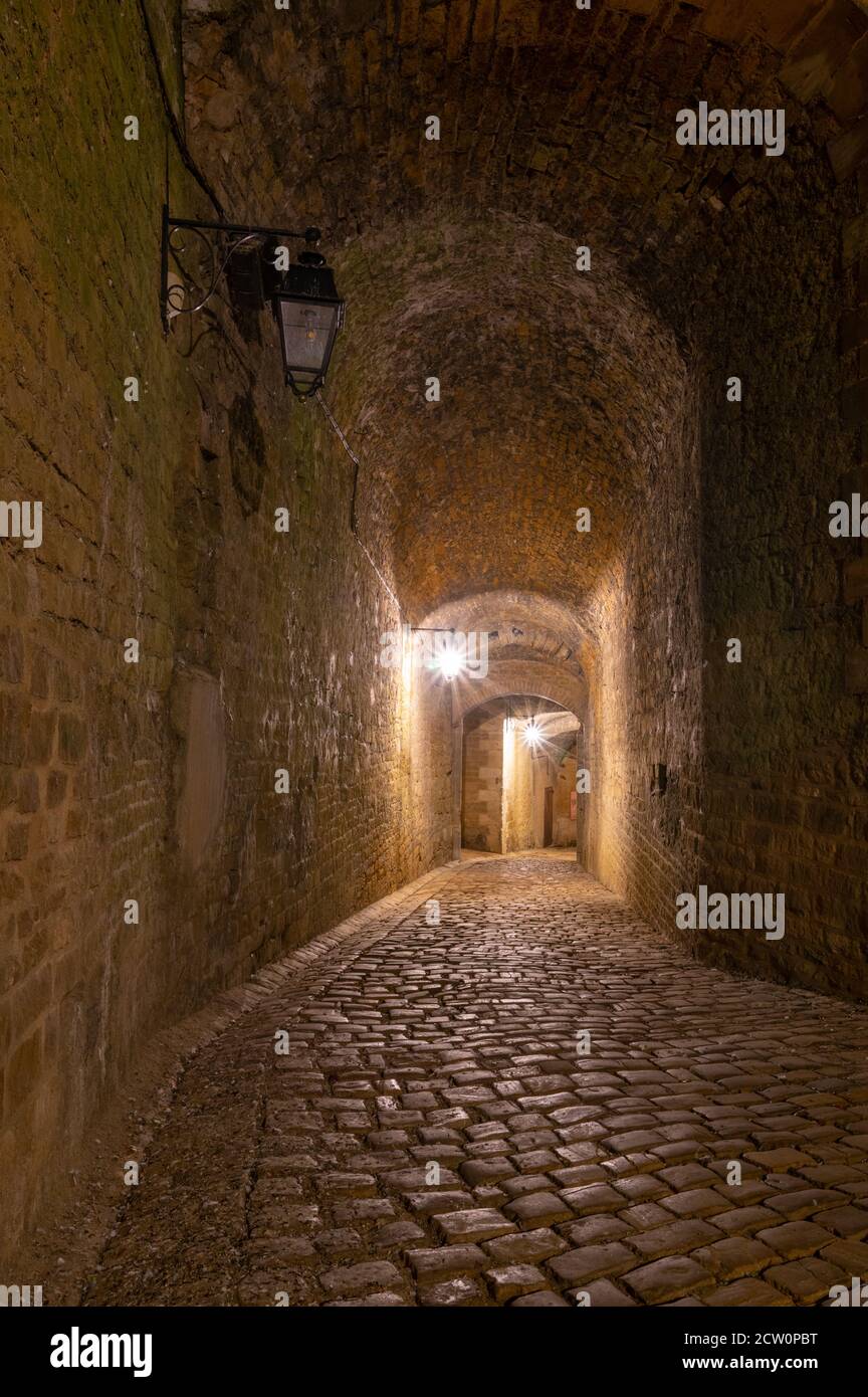 Schattiger Eingang in das riesige Schloss von Sedan, keine Leute, nachts unter Straßenlaternen Stockfoto